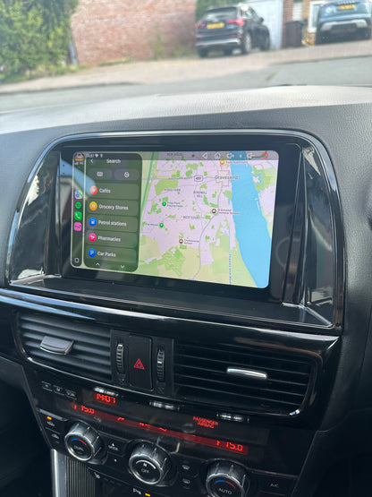 Mazda CX5 2012–2015 dashboard touchscreen displaying Apple Maps and nearby place categories.