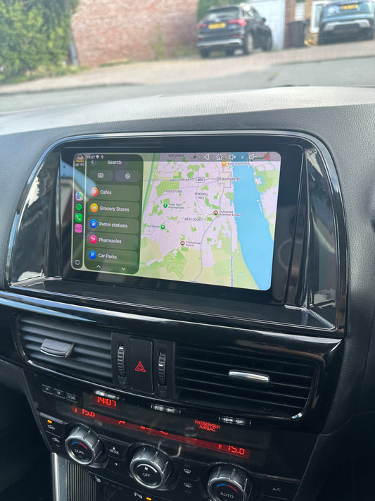 Mazda CX5 2012–2015 dashboard touchscreen displaying Apple Maps and nearby place categories.