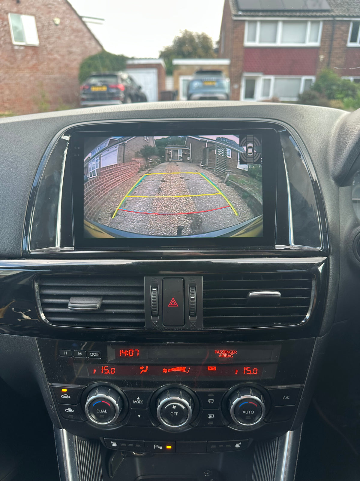 Mazda CX5 2012–2015 fitted touchscreen showing factory reverse camera view with coloured parking guidelines.